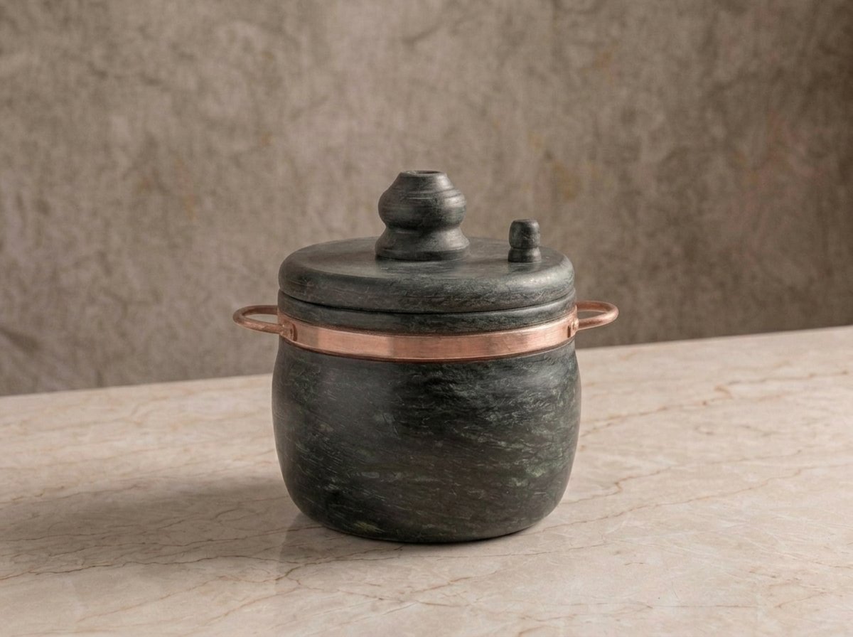 1 Panela de Pressão de pedra sabão com alças de cobre sobre bancada de mármore